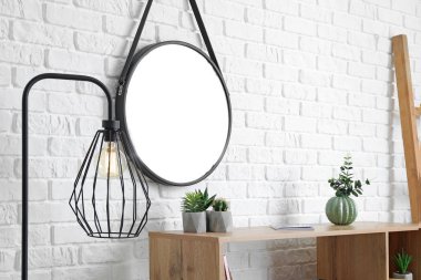 Beyaz tuğla duvara yakın lamba ve ayna ile modern oda iç