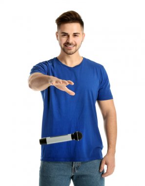 Yakışıklı adam beyaz arka plan üzerinde mikrofon bırakarak