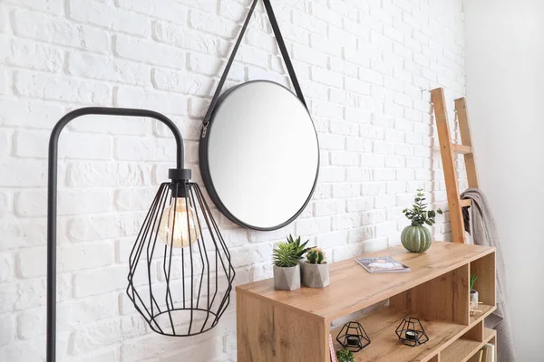 Shelf unit dekat bata putih dinding dengan cermin — Stok Foto