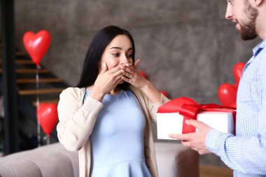 Genç bir kadın erkek arkadaşından hediye alıyor.
