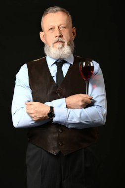 Koyu arka plan üzerinde zarif olgun sommelier Portresi