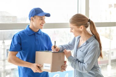 Woman signing documents to confirm receiving of order from delivery company