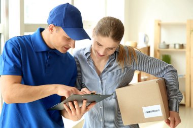 Woman signing documents to confirm receiving of order from delivery company