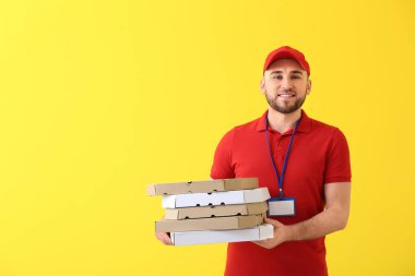 Renkli arka planda pizza kutuları ile Yakışıklı teslimat adam