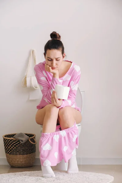 Fiatal nő puha papírt ül a WC-csészében a mosdó — Stock Fotó