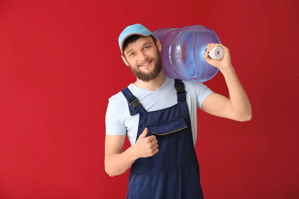 Delivery courier with bottle of water on color background — Stock Photo, Image