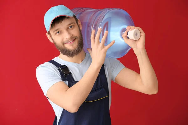 Delivery courier with bottle of water on color background — Stock Photo, Image