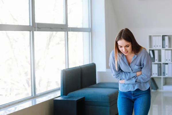 Mujer que sufre de dolor de estómago en casa — Foto de Stock