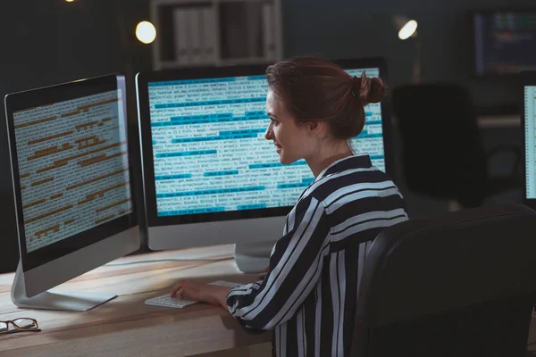 Female programmer working in office at night