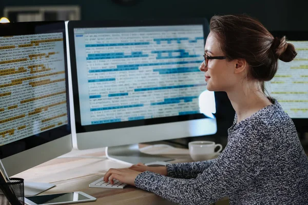 Programadora femenina trabajando en la oficina por la noche — Foto de Stock