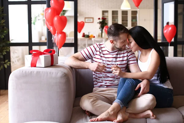 Счастливая молодая пара пьет шампанское дома в День Святого Валентина — стоковое фото