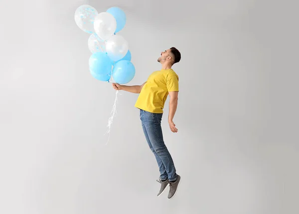 明るい背景に気球を持つ若者をジャンプ — ストック写真