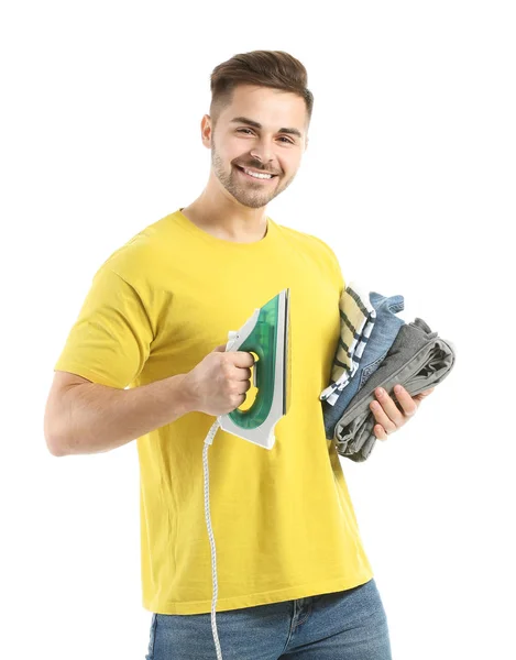 Young man with iron and clothes on white background — Stok fotoğraf