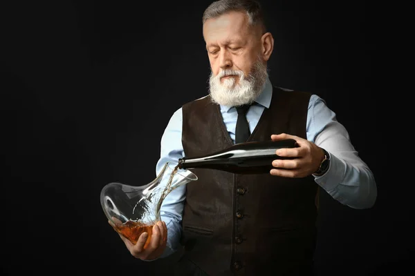 Retrato de elegante sommelier maduro sobre fondo oscuro — Foto de Stock