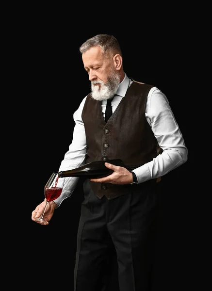 Porträtt av elegant mogen sommelier på mörk bakgrund — Stockfoto