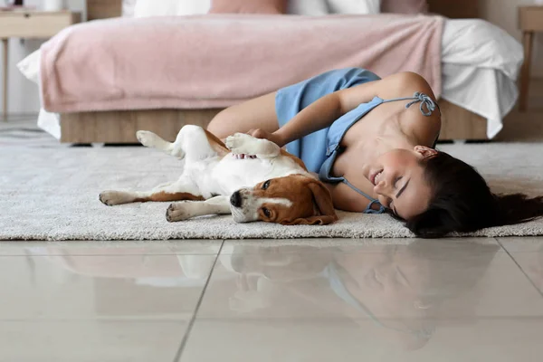 Jovem mulher com cão bonito deitado no chão em casa — Fotografia de Stock