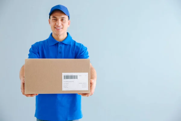 Uomo di consegna con scatola su sfondo a colori — Foto Stock