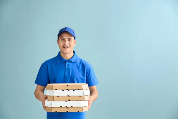 Entrega hombre con cajas de pizza en el fondo de color — Foto de Stock