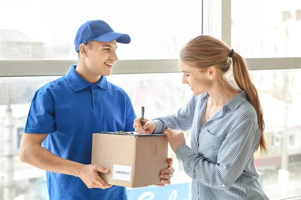 Mujer firmando documentos para confirmar la recepción de la orden de la empresa de entrega — Foto de Stock