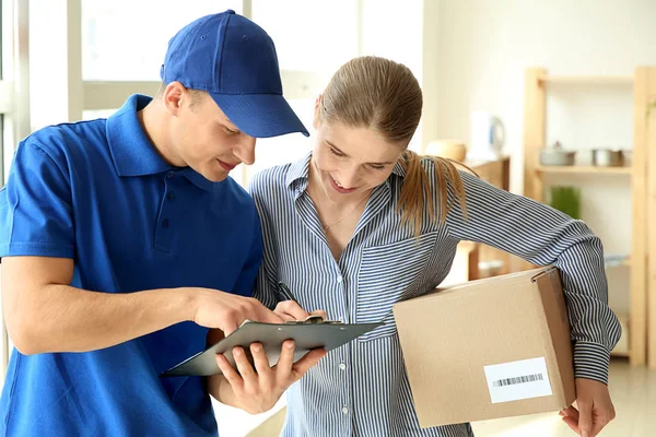 Woman signing documents to confirm receiving of order from delivery company