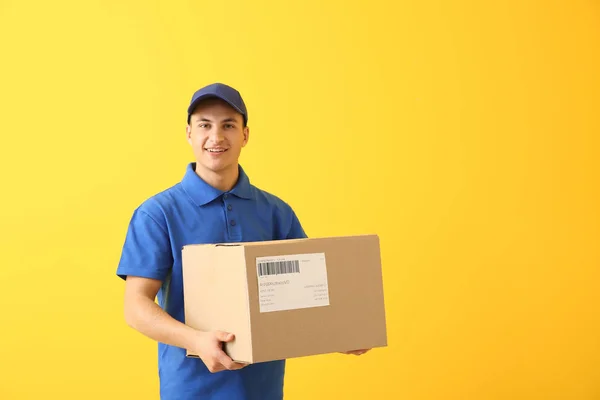 Entrega homem com caixa no fundo de cor — Fotografia de Stock