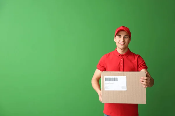 Delivery man med box på färg bakgrund — Stockfoto