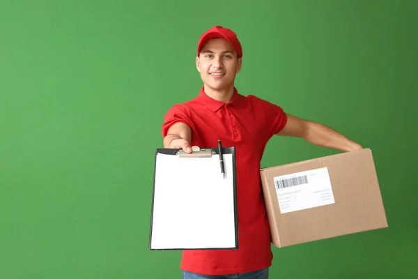 Entrega homem com caixa e área de transferência em fundo de cor — Fotografia de Stock