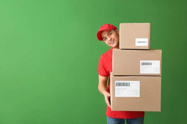 Liefermann mit Schachteln auf farbigem Hintergrund — Stockfoto