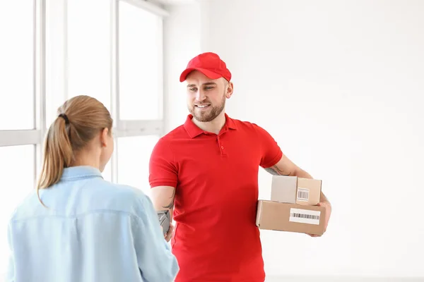 Woman paying courier for delivery of parcels — Stok fotoğraf