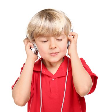 Beyaz arka planda müzik dinleyen sevimli küçük çocuk.