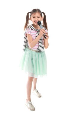 Beyaz arka plan aleyhine şarkı söyleyen mikrofonlu küçük kız