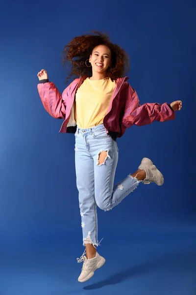 Jumping young woman on color background — Stock Photo, Image