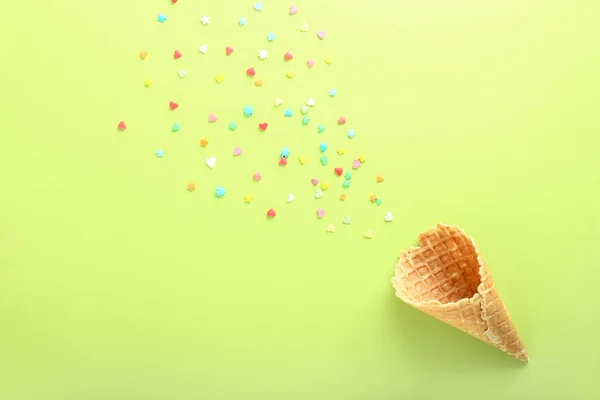 Crunchy wafer cone with sprinkles on color background — Stock Photo, Image