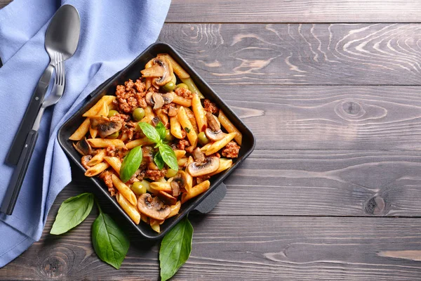 Panela de ato de fritar com massa fervida saborosa em mesa de madeira — Fotografia de Stock