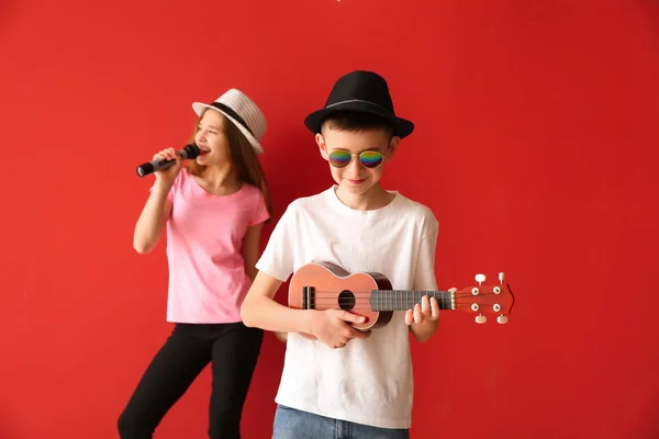 Маленькие музыканты играют на цветном фоне — стоковое фото