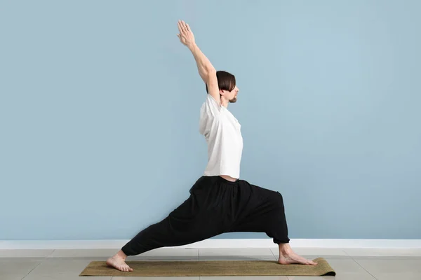 Sporty man practicing yoga indoors — Stock Photo, Image