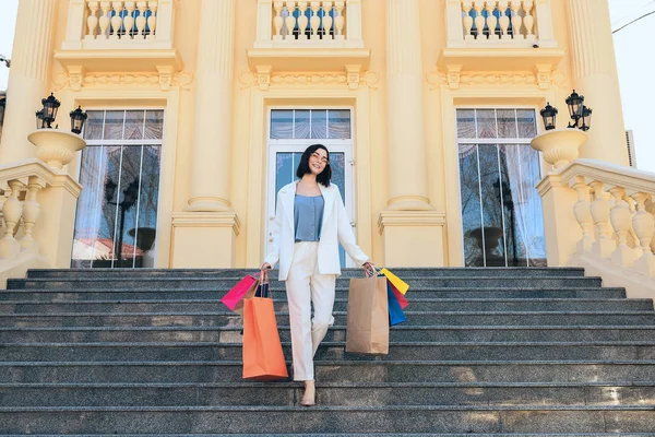 Hermosa mujer joven con bolsas de compras en las escaleras al aire libre —  Fotos de Stock