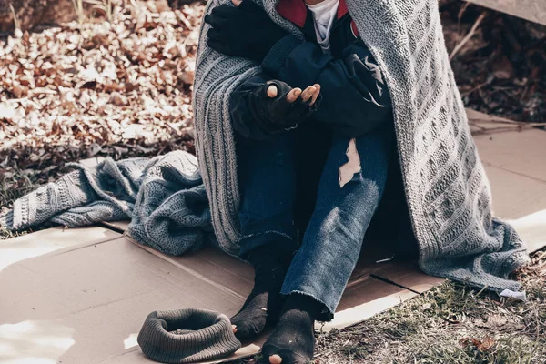 Poor homeless woman begging for help outdoors