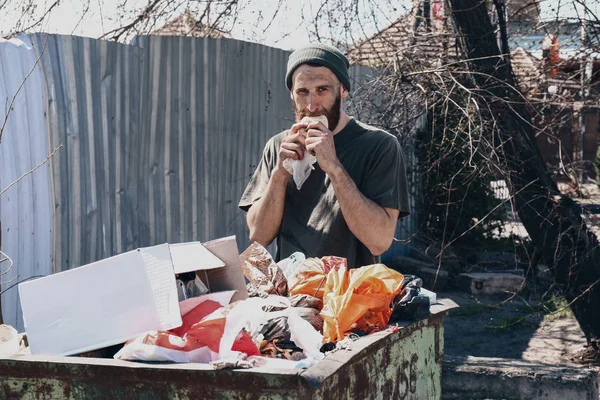 Pobre vagabundo cerca de la papelera al aire libre —  Fotos de Stock