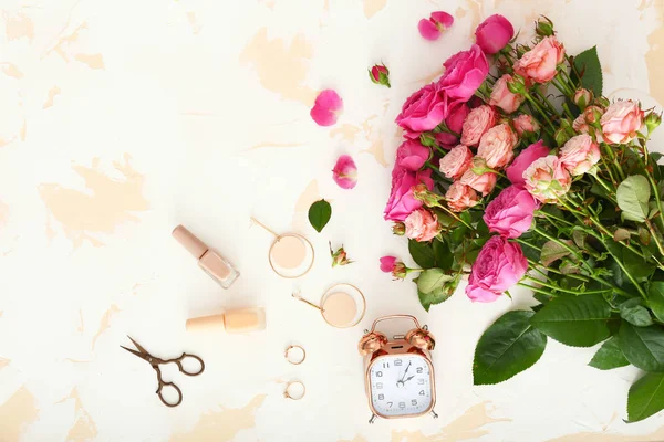 Hafif arka planda çalar saat, takı, makas ve oje ile güzel gül buketi