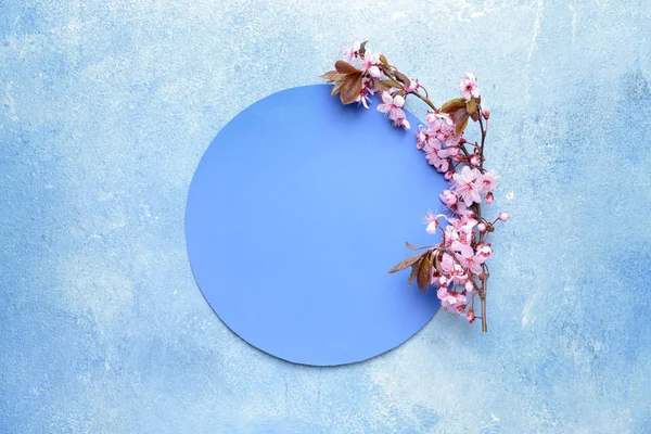 Paper circle and beautiful blossoming branches on color background — Stock Photo, Image