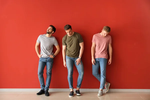 Fashionable young men near color wall — Stock Photo, Image