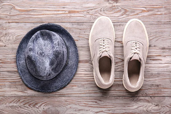 Male shoes and hat on wooden background