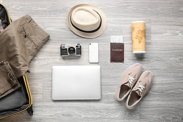 Mannelijke kleding en accessoires met fotocamera, mobiele telefoon, laptop en reis objecten op houten achtergrond — Stockfoto