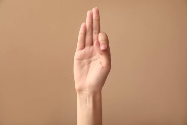 Renk arka planda F harfini gösteren kadın el