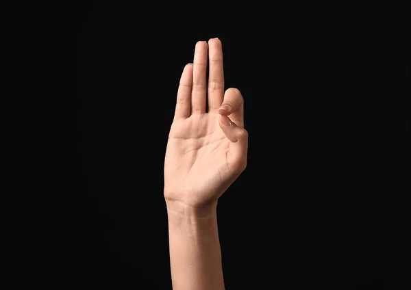 Kobiece ręka pokazując literę F na ciemnym tle — Zdjęcie stockowe