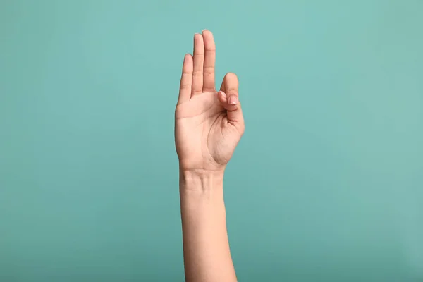 Female hand showing letter F on color background — Stock Photo, Image