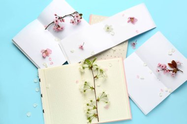 Güzel çiçek dalları ve renkli arka planda açık defterler