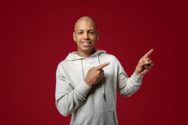 Yakışıklı Afrikalı-Amerikalı adam renk arka plan üzerinde bir şey işaret