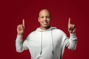 Yakışıklı Afrikalı-Amerikalı adam renk arka plan üzerinde bir şey işaret